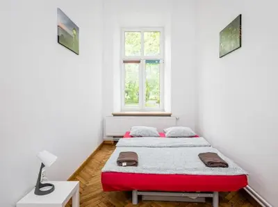 a white room with a bed and a window at Wąsik in Kraków