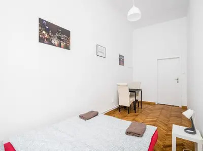 a white room with a bed and a desk in it at Wąsik in Kraków