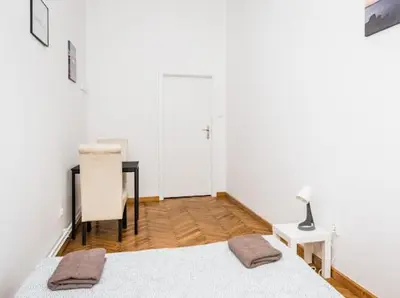 a bedroom with a desk and a bed and a table at Wąsik in Kraków