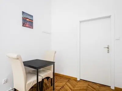 a room with a table and two chairs and a door at Wąsik in Kraków