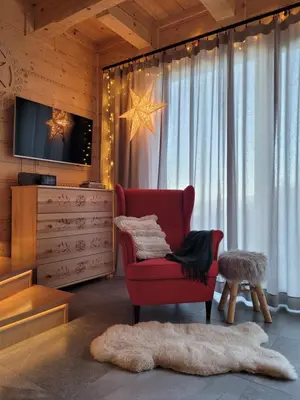 a living room with a red chair and a tv at Domek na Kleninie z gorącą balią in Kamienica