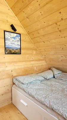 a bedroom with a bed in a wooden cabin at Domek na Kleninie z gorącą balią in Kamienica