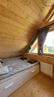 a log cabin with two beds in a room at Domek na Kleninie z gorącą balią in Kamienica