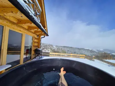 a person in a hot tub in a house at Domek na Kleninie z gorącą balią in Kamienica