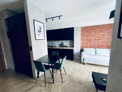 a kitchen and living room with a table and chairs at Apartament Róża 1 Zator - 2 km od Energylandii in Zator