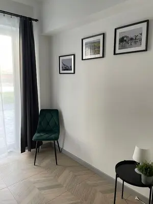 a living room with a green chair and a table at Apartament Róża 1 Zator - 2 km od Energylandii in Zator