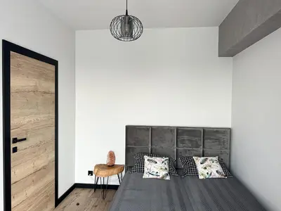 a bedroom with a bed with a black headboard at ApartLoft 64 Apartament Zator in Zator