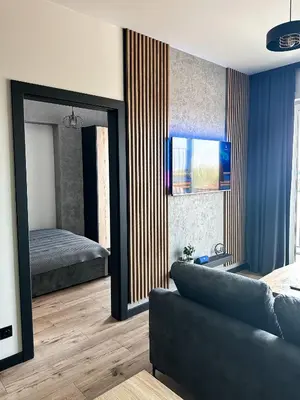 a bedroom with a couch and a bed and a mirror at ApartLoft 64 Apartament Zator in Zator