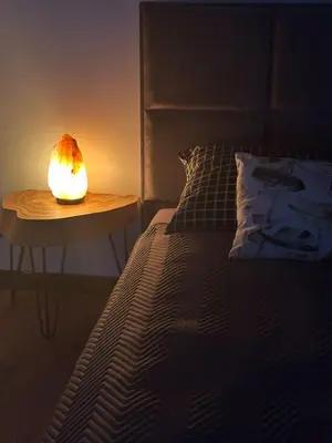 a lamp on a table next to a bed at ApartLoft 64 Apartament Zator in Zator