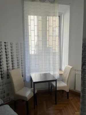 a dining room with a table and two chairs and a window at PIRANIA in Kraków