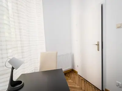 a desk with a lamp and a chair in a room at PIRANIA in Kraków