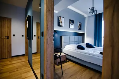 a bedroom with a bed and blue walls at Apartament No 61 Blue Holiday Home Zator in Zator
