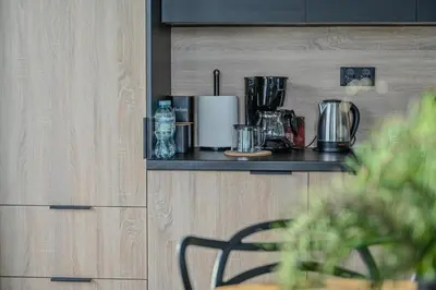a kitchen with a counter top with a chair on a shelf at Apartament No 61 Blue Holiday Home Zator in Zator