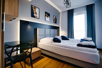 a bedroom with a bed and a desk and a chair at Apartament No 61 Blue Holiday Home Zator in Zator