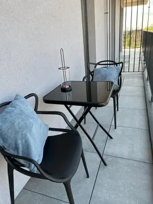 a table and chairs with pillows on a balcony at Apartament No 61 Blue Holiday Home Zator in Zator
