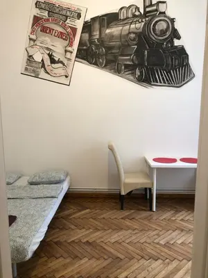 a room with a train picture on the wall and a table at Wawel in Kraków