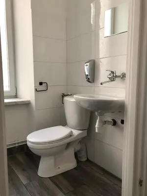 a white bathroom with a toilet and a sink at Wawel in Kraków