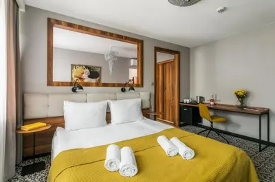 a bedroom with a large bed with a yellow blanket at No.23 Premium Aparthotel in Kraków