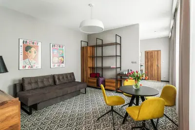 a living room with a couch and a table and chairs at No.23 Premium Aparthotel in Kraków