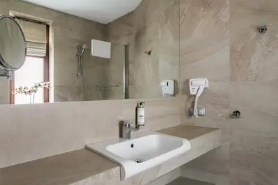 a bathroom with a sink and a shower and a mirror at No.23 Premium Aparthotel in Kraków