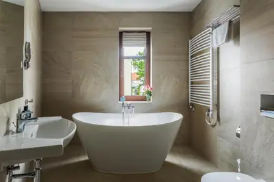 a bathroom with a tub and two sinks and a window at No.23 Premium Aparthotel in Kraków