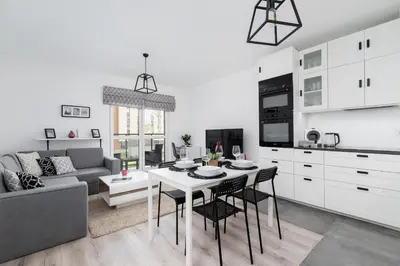 a kitchen and living room with a table and chairs at Krowodrza Apartment Premium with Balcony by Renters Prestige in Kraków