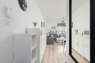a white kitchen with white cabinets and a living room at Krowodrza Apartment Premium with Balcony by Renters Prestige in Kraków