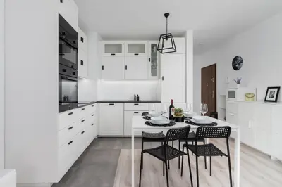 a white kitchen with a table and chairs at Krowodrza Apartment Premium with Balcony by Renters Prestige in Kraków
