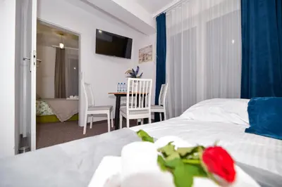 a bedroom with a bed and a table and chairs at REZYDENCJA ZATOR in Zator