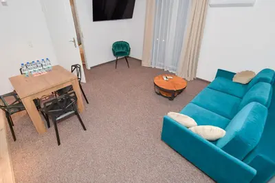 a living room with a blue couch and a table at REZYDENCJA ZATOR in Zator
