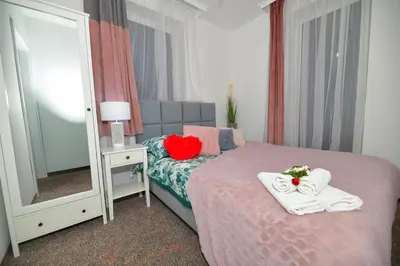 a bedroom with a bed with towels and a mirror at REZYDENCJA ZATOR in Zator