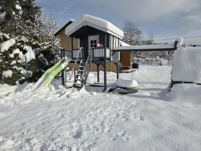 a playground in the snow in front of a house at Domek Komfort w górach przy Parku in Rabka