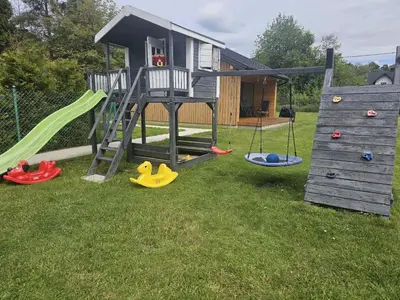 a playground with a slide and a play house at Domek Komfort w górach przy Parku in Rabka