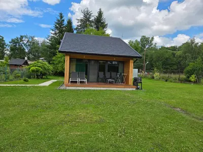 a small cabin with two chairs in a yard at Domek Komfort w górach przy Parku in Rabka