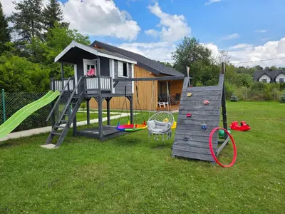 a play house with a slide and a playground at Domek Komfort w górach przy Parku in Rabka