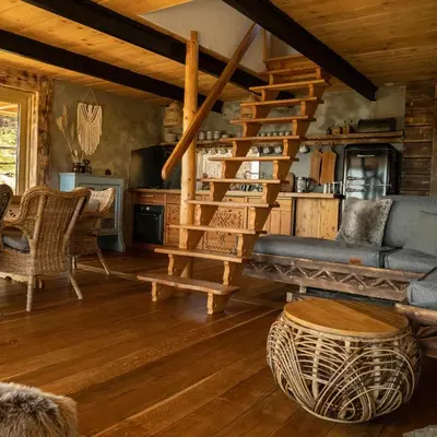 a living room with a staircase in a log cabin at Górna Chata Mountains Chalet in Ochotnica Górna