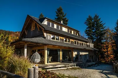 a large wooden house with a gambrel roof at Górna Chata Mountains Chalet in Ochotnica Górna