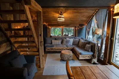 a living room with a couch and stairs in a cabin at Górna Chata Mountains Chalet in Ochotnica Górna