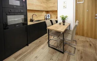 a kitchen with a wooden table and a black refrigerator at Cozy Apartment In Zator With Wifi in Zator