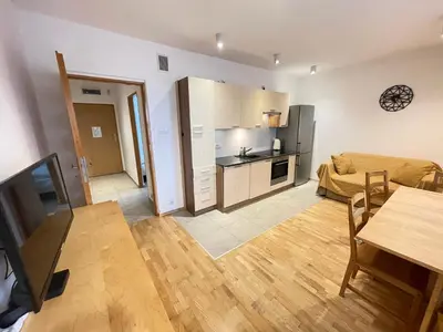 a living room with a kitchen and a dining room at Apartament Park Zakrzowek in Kraków
