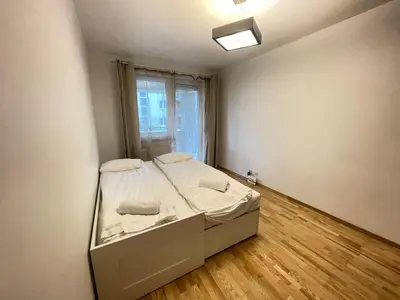 a small bed in a room with a window at Apartament Park Zakrzowek in Kraków