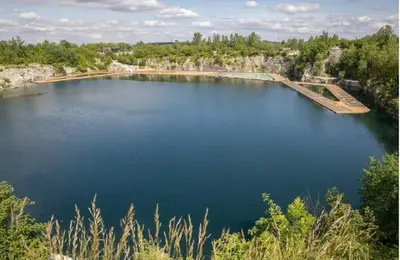 a large body of blue water with trees in the background at Apartament Park Zakrzowek in Kraków