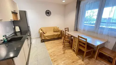 a small kitchen with a table and a bed at Apartament Park Zakrzowek in Kraków