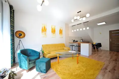 a living room with a yellow couch and a table at Włodarska 11 in Kraków