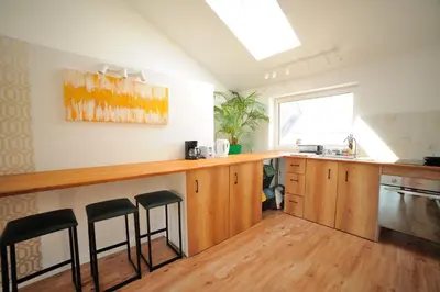 a kitchen with a counter and stools in it at Włodarska 11 in Kraków