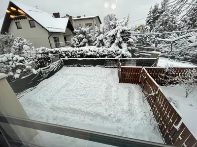 a snow covered backyard with a pool in the yard at Włodarska 11 in Kraków