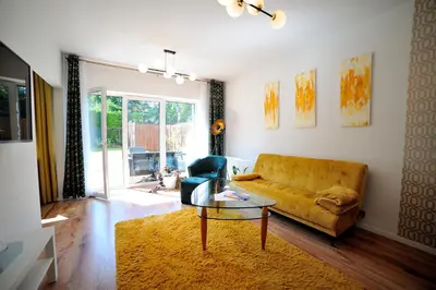 a living room with a yellow couch and a glass table at Włodarska 11 in Kraków