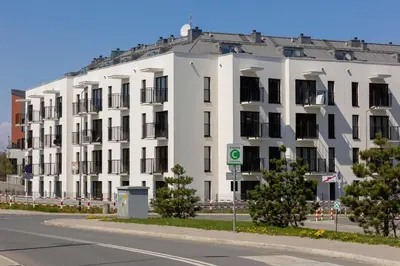 a large white building on the side of a street at Casa Feliz Zabłocie Studio for 4 Guests Cracow by Noclegi Renters in Kraków