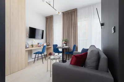 a living room with a couch and a table with chairs at Casa Feliz Zabłocie Studio for 4 Guests Cracow by Noclegi Renters in Kraków