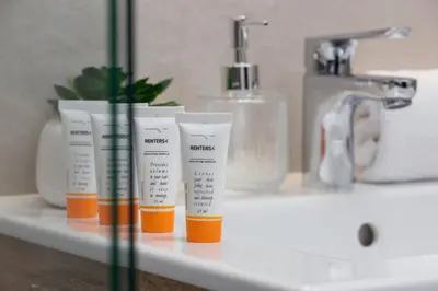a bathroom counter with three tubes of toothbrushes and a sink at Casa Feliz Zabłocie Studio for 4 Guests Cracow by Noclegi Renters in Kraków